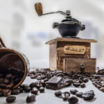 Spilled coffee beans and coffee grinder