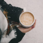 A lady holding a cup of coffee in a cold weather