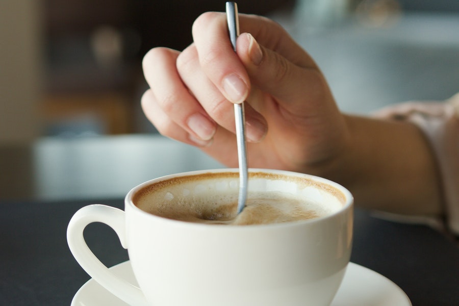 Person stirring a coffee