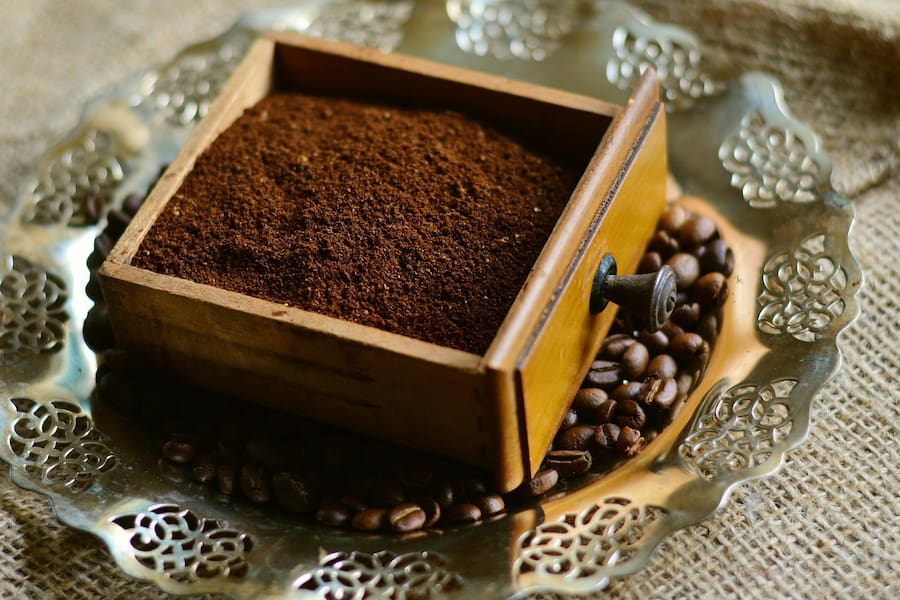 An image of coffee grounds and coffee beans