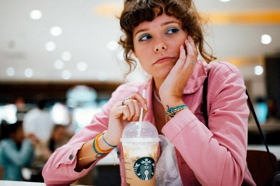An image of a woman not happy drinking her coffee