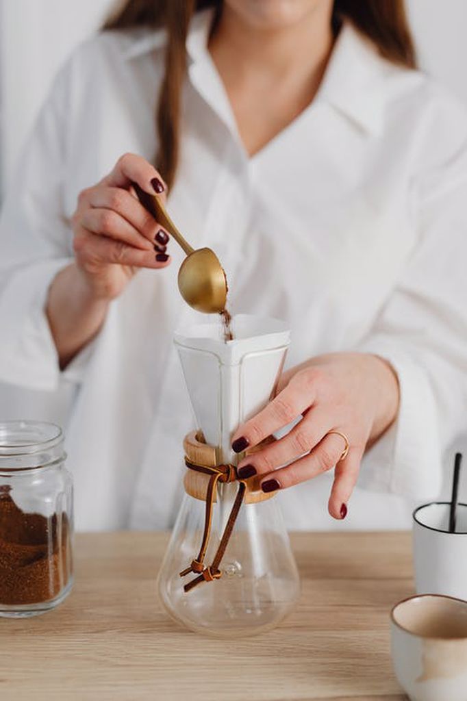 Woman putting coffee grounds on a glass
